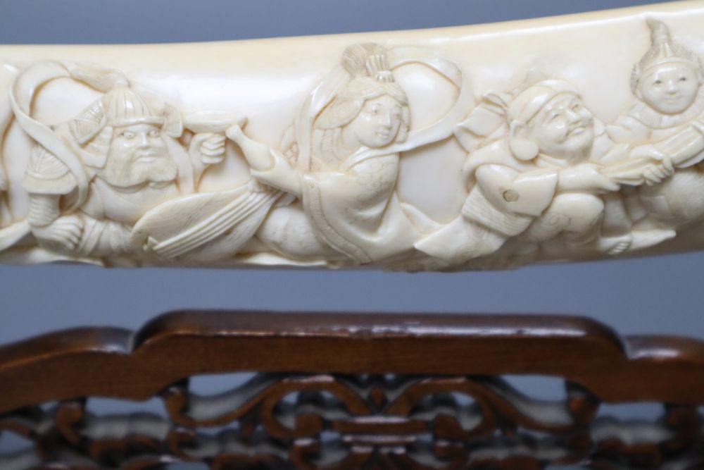 A Japanese ivory Seven immortals tusk carving, early 20th century, wood stand, signed, 44cm excl. stand